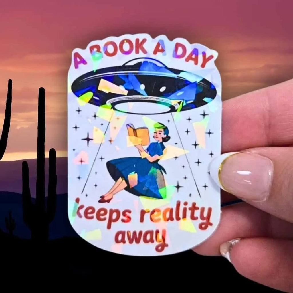 A Book A Day Keeps Reality Away – Holographic Book Lover Sticker, Alien UFO Abduction Reading Sticker, Bookish Sticker, Sci - Fi Reader Gift - Holographic Sticker | The TabbyLoaf