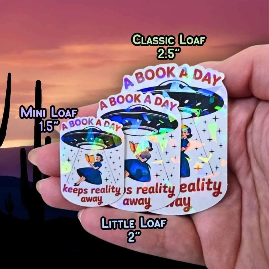 A Book A Day Keeps Reality Away – Holographic Book Lover Sticker, Alien UFO Abduction Reading Sticker, Bookish Sticker, Sci - Fi Reader Gift - Holographic Sticker | The TabbyLoaf
